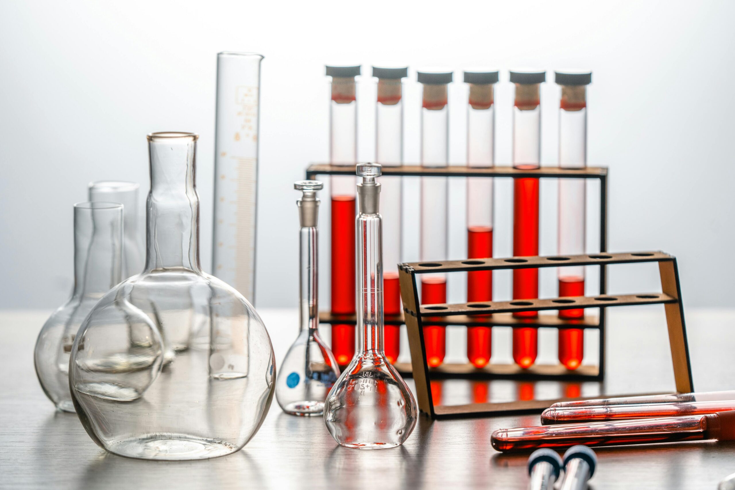project-3 Close-up of various lab glassware with red liquids, ideal for scientific or educational use.