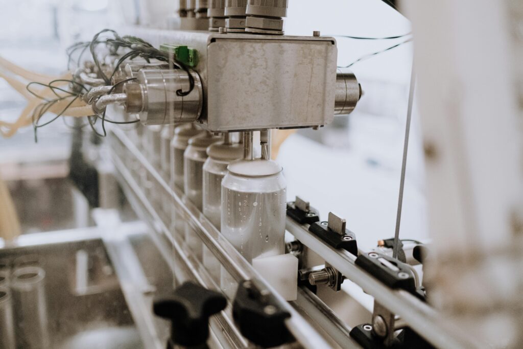 project-4 Close-up of an automated can filling machine in a beverage production line.